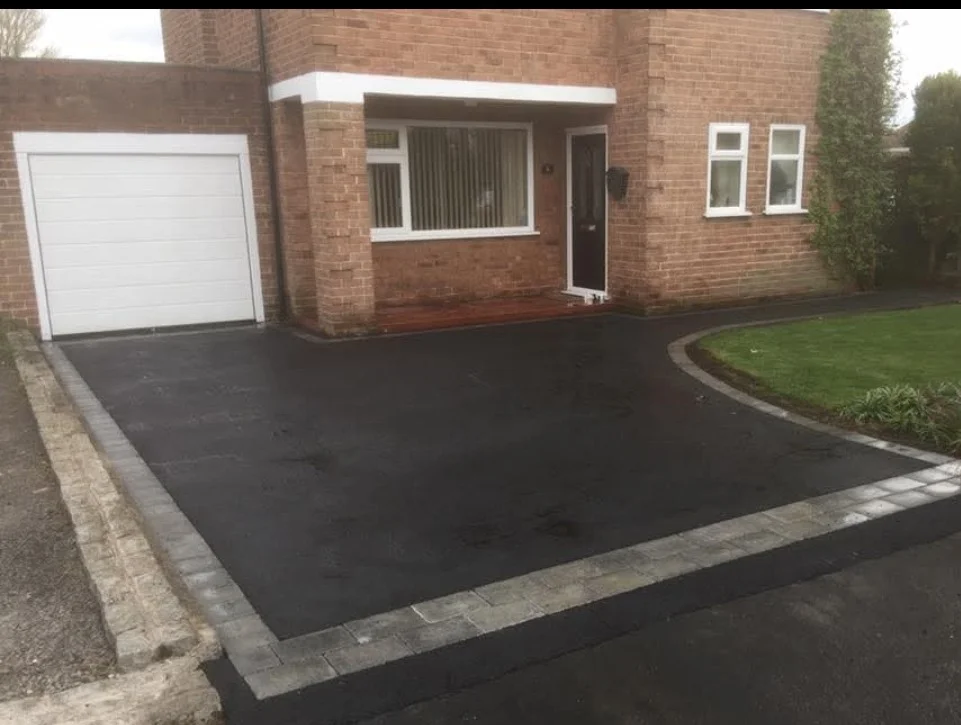 Tarmac driveway with a curved lawn edge and contrasting paving