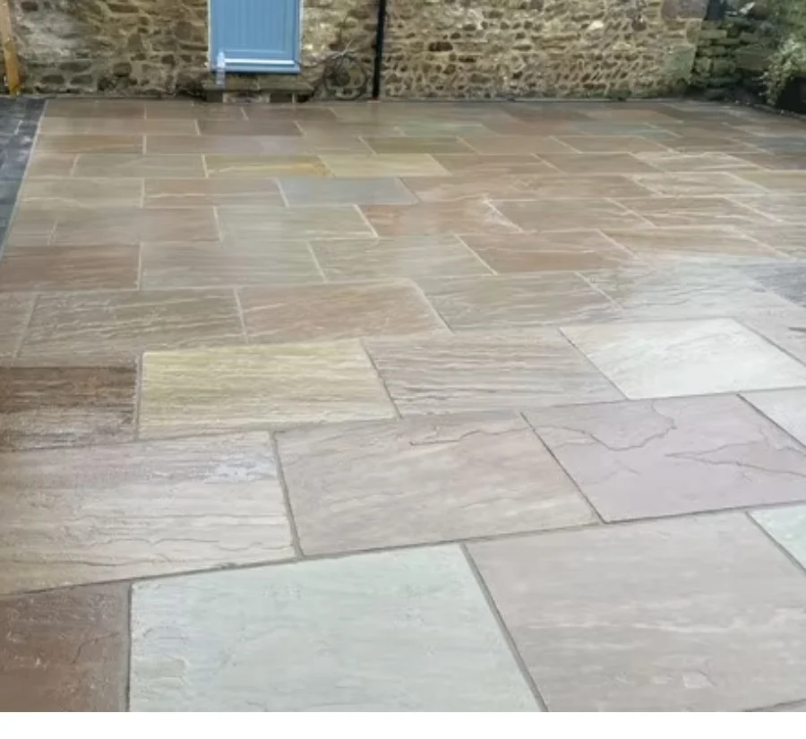Multicoloured stone paving beside a stone building