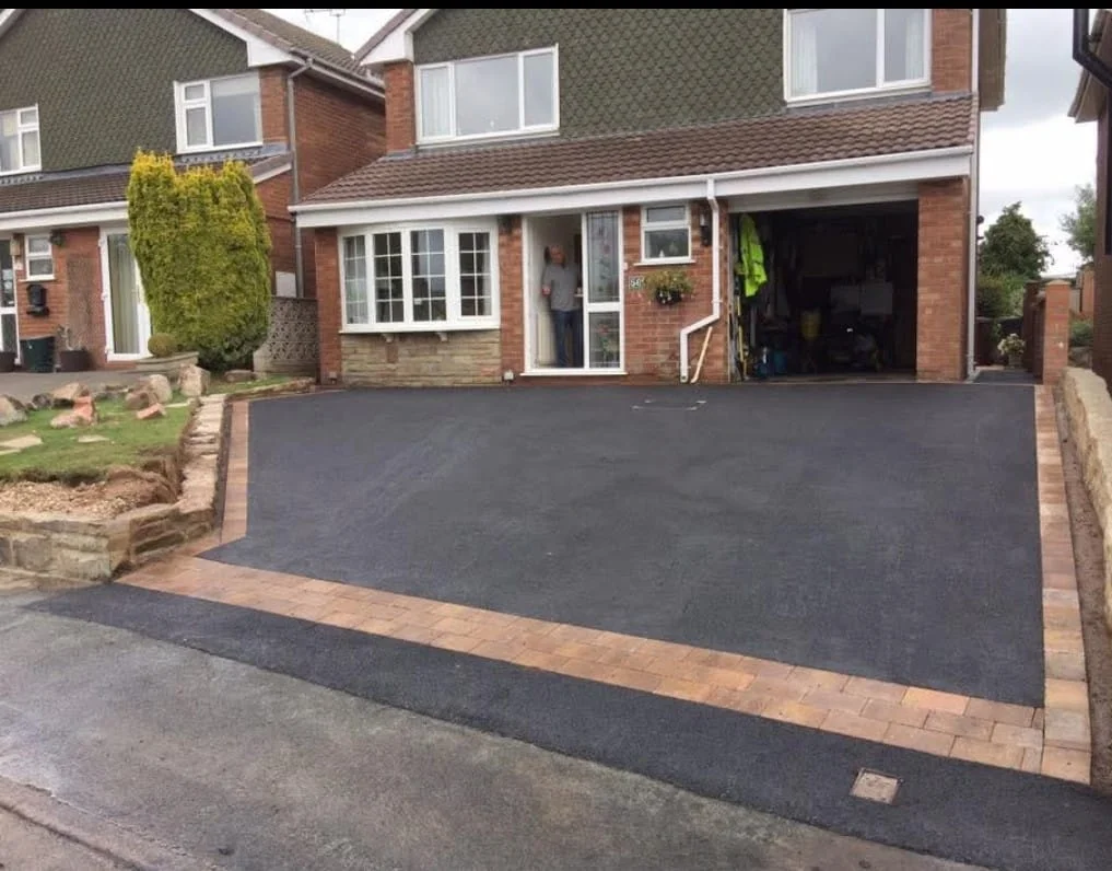Tarmac driveway with contrasting brick edging outside a house